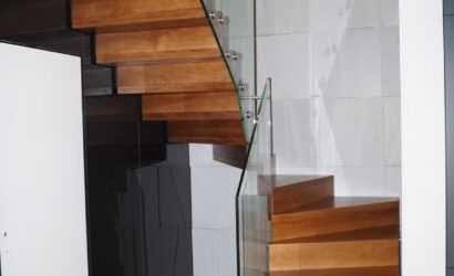 Drewniane schody wewnętrzne ze szklanymi balustradami