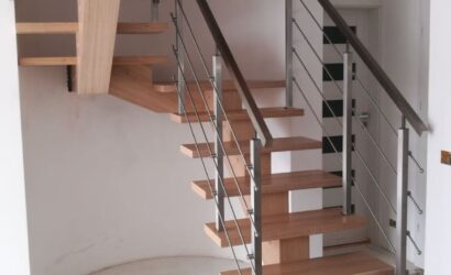 Drewniane schody wewnętrzne z metalowymi balustradami